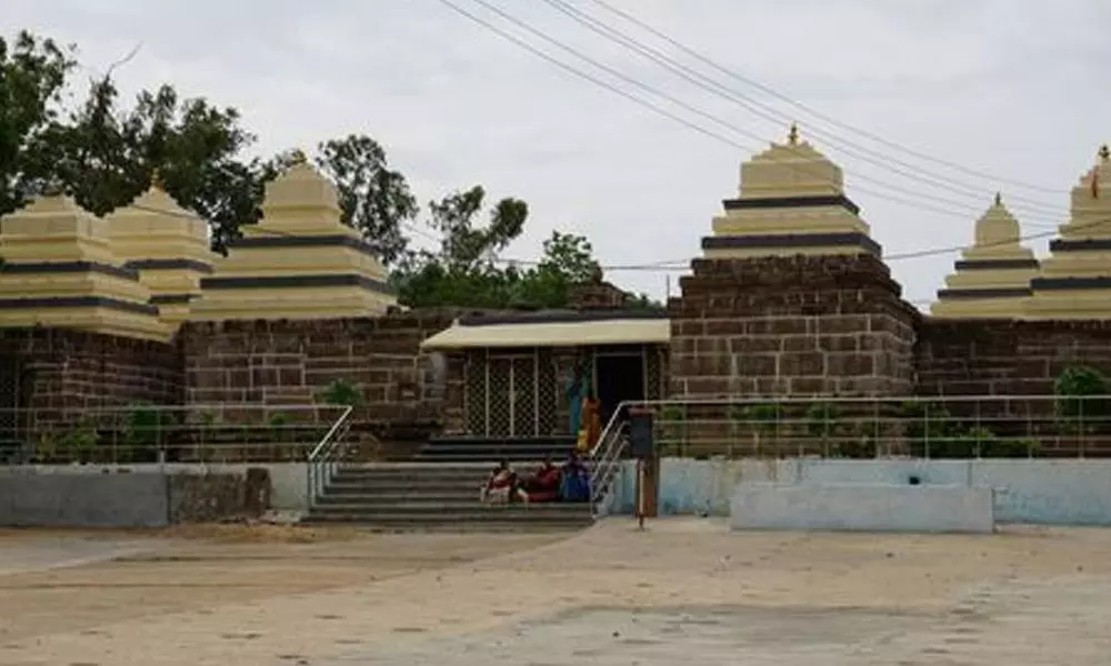 Front view of Somasila Shiva Temple with ancient stone walls, cream-colored gopurams, and steps leading to the main entrance