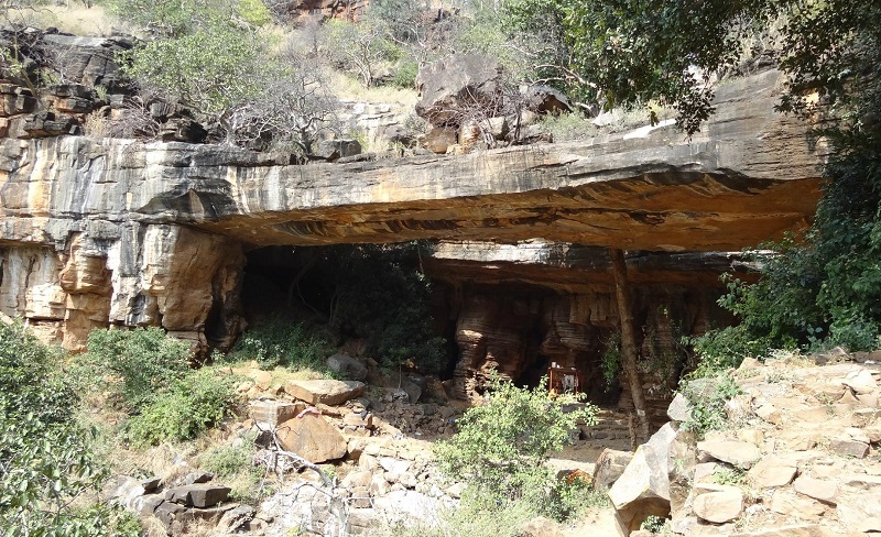 Natural rock arch formation and cave temples at Uma Maheshwaram in the Nallamala Hills, featuring rocky landscapes, ancient shrines, and dense forest surroundings