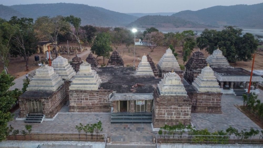 Aerial view of Somasila Temple complex with ancient stone shrines, white gopurams, and scenic hills in the background, a popular Shiva pilgrimage site near the Krishna River in Telangana